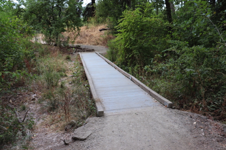 The compacted gravel trail transitions to boardwalk with edge protection The compacted gravel trail transitions to boardwalk with edge protection